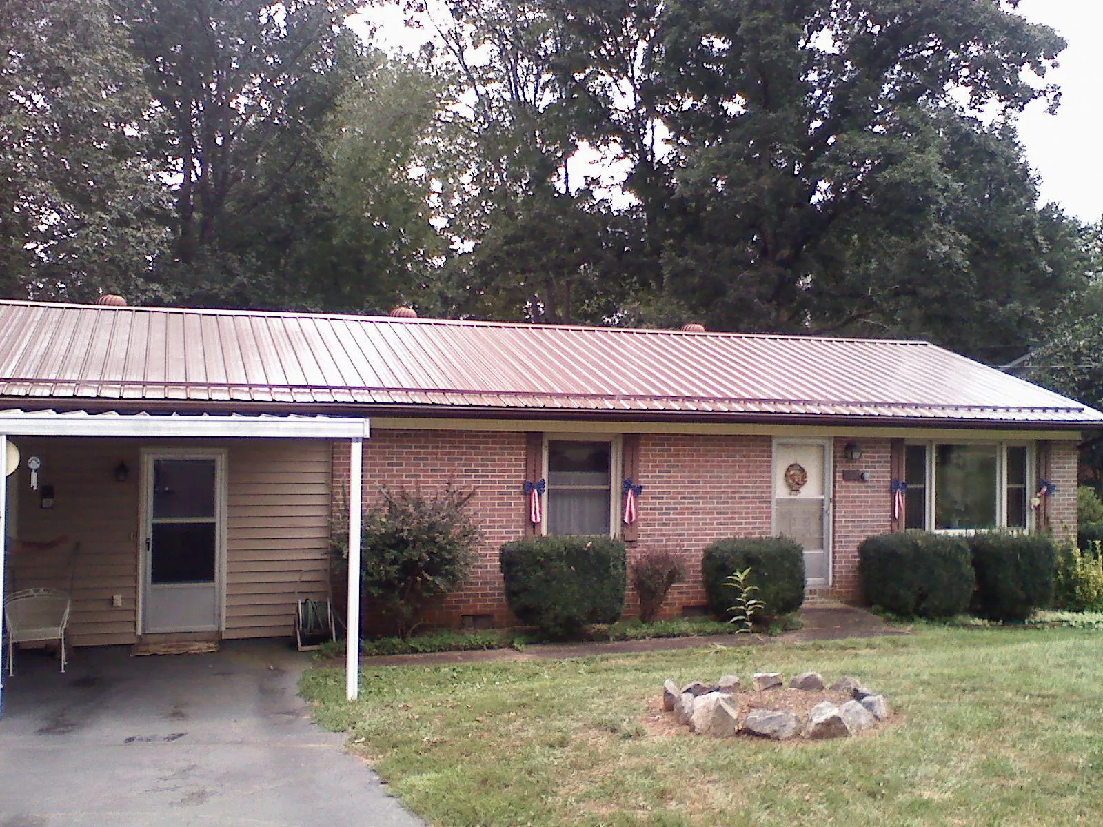 Bronze metal roof and carport on a brick ranch home — Roof Repair work by our crew in Lake Lillian